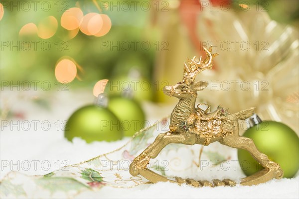 Beautiful golden christmas reindeer ornament among snow