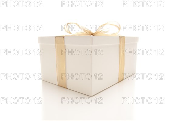 White gift box with gold ribbon and bow isolated on a white background