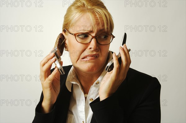 Business woman expresses her frustration as she shuffles two cell phones