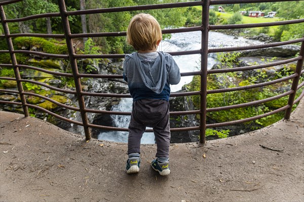 Boy looks at the rushing waters