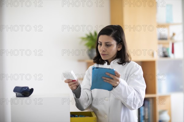 Pharmacist with medicine in a pharmacy working with modern technology and smock