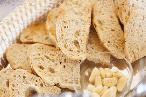 Tray of fresh made sourdough bread with garlic cloves on a serving table