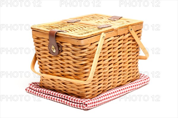 Picnic basket and folded blanket isolated on a white background