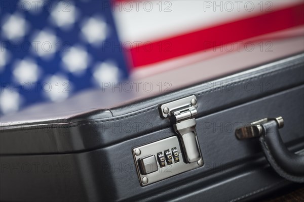 Black leather briefcase resting on table with american flag behind