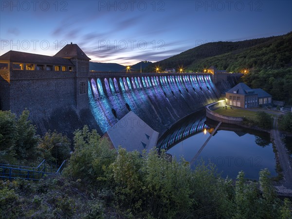 Illuminated dam wall in the evening twilight