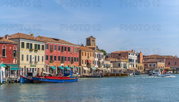 Colorful houses and boats on a canal of Murano