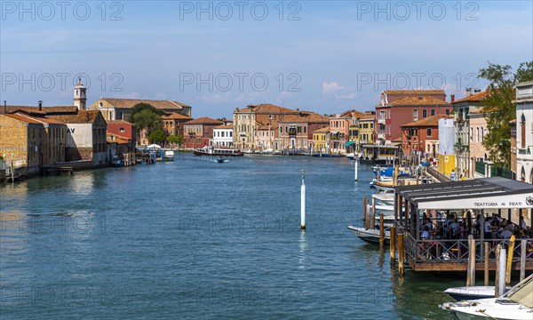 Colorful houses and boats on a canal of Murano