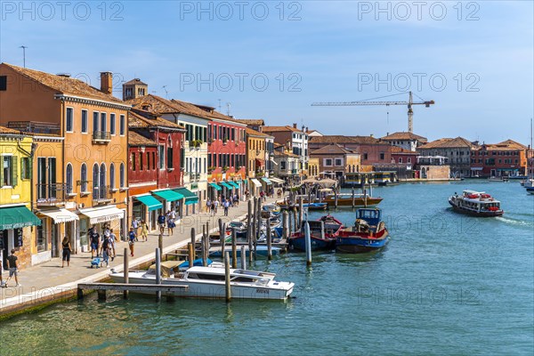 Colorful houses and boats on a canal of Murano