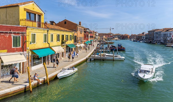 Colorful houses and boats on a canal of Murano