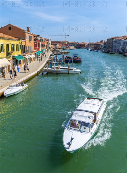 Colorful houses and boats on a canal of Murano