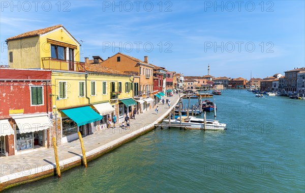 Colorful houses and boats on a canal of Murano