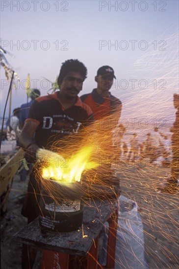 Ein Mann roestet Mais in Marina Beach