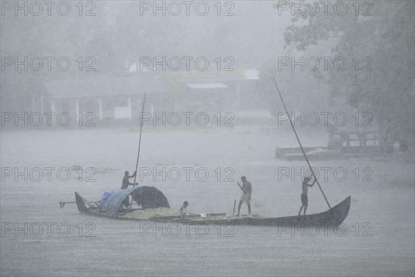 Collecting sand on a boat in the Pamba River