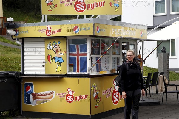 Woman in front of hot dog stand