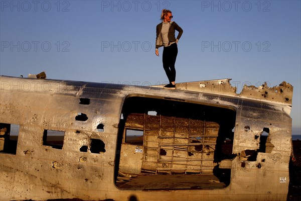 Woman climbing on plane wreckage