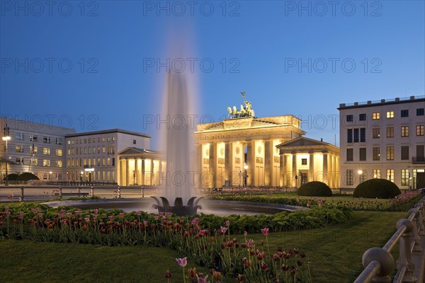 Illuminated Brandenburg Gate with fountain and Pariser Platz in the evening