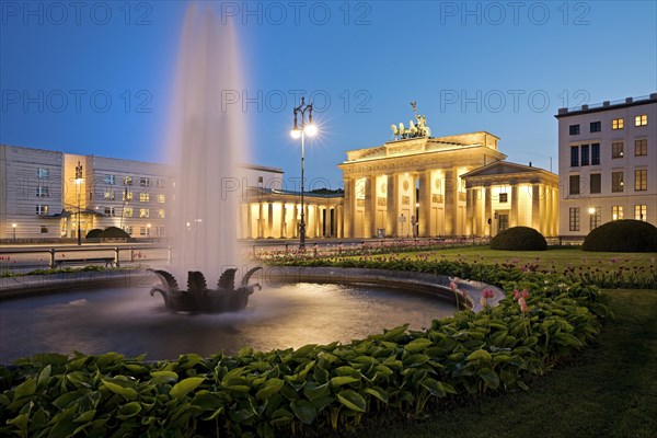 Illuminated Brandenburg Gate with fountain and Pariser Platz in the evening