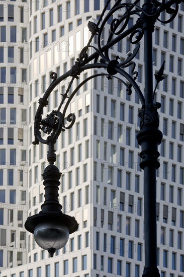 Old Berlin gas lantern in front of the modern high-rise Hotel Motel One Berlin-Upper West