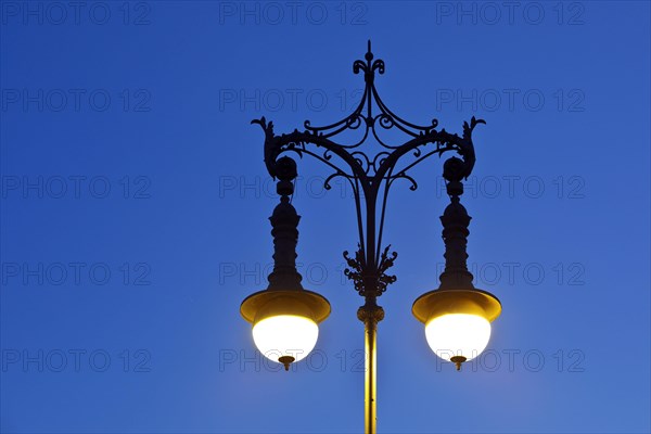 Shining old Berlin gas lantern in the evening