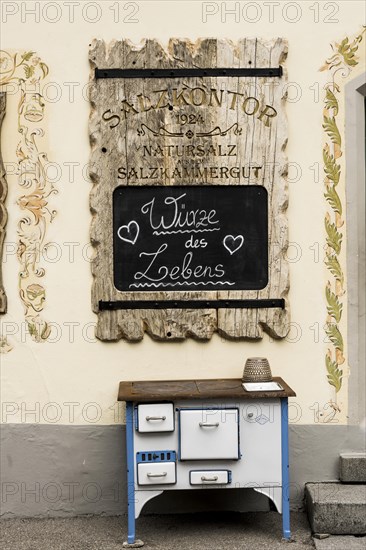 Advertising board and old stove in front of the soap manufactory Salzkontor in the UNESCO World Heritage Hallstatt at Lake Hallstatt