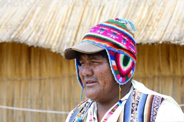 Man with colorful knitted cap on a floating island of the Uro