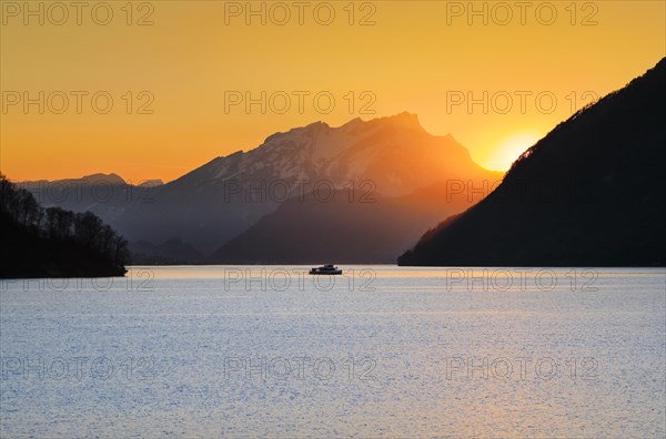 View from Brunnen on a boat on the Vierwaldstaettersee with Pilatus in the background at sunset