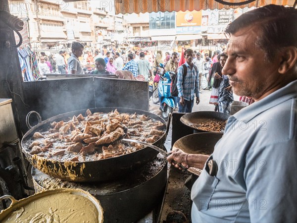Vendor prepares tasty fried snacks at a street kitchen