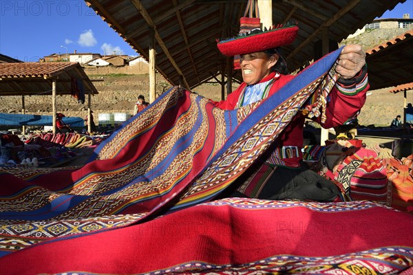 Indigenous old woman selling colorful blankets at the weekly market market