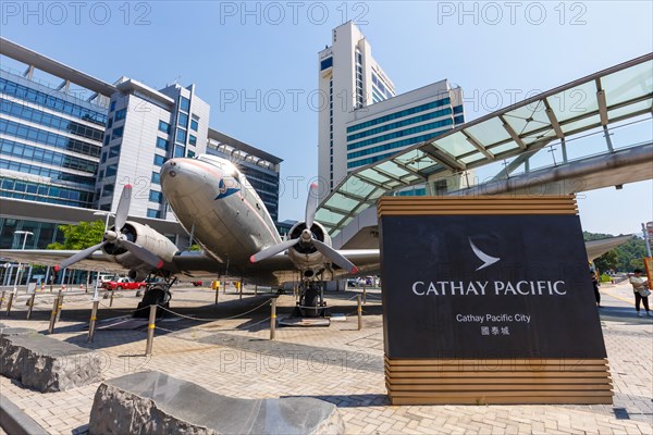 A Douglas DC-3 aircraft with registration VR-HDA in front of Cathay Pacific City at Hong Kong Airport