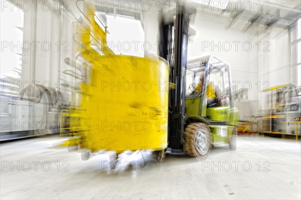 Forklift truck in motion in an industrial hall