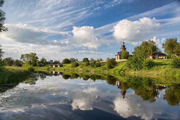 River with clouds and wooden russian orthodox church