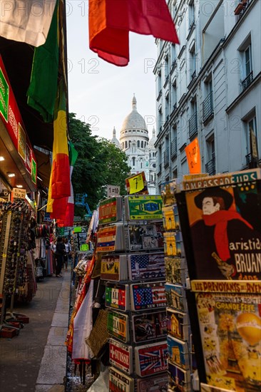 Street with souvenir shops on Montmartre with the Basilica Sacre-Coeur in the background