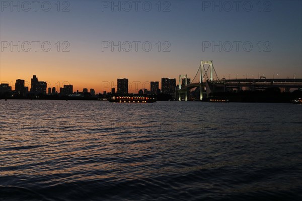 View from Odaiba Beach to Tokyo Bay with Rainbow Bridge at dusk