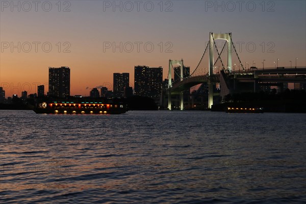 View from Odaiba Beach to Tokyo Bay with Rainbow Bridge at dusk