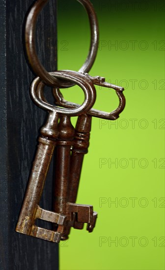 Key ring with old keys hanging on a wooden post