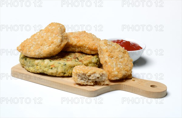 Meat substitute on wooden board and tray with ketchup