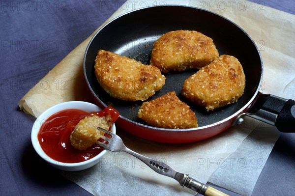 Meat substitute in pan and bowl with ketchup