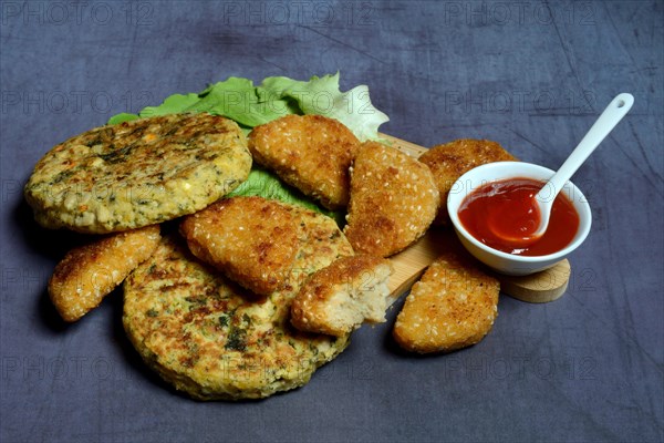 Meat substitute on wooden board and tray with ketchupl