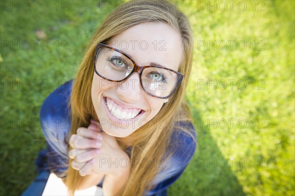 Fun wide angle portrait of pretty young woman at the park