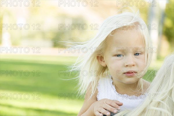 Melancholy portrait of cute little girl outside in park