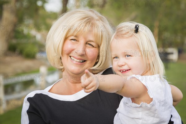 Affectionate grandmother and granddaughter playing outside at the park