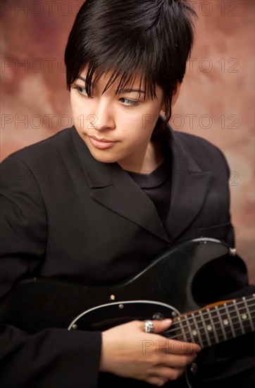 Multiethnic girl poses with her electric guitar