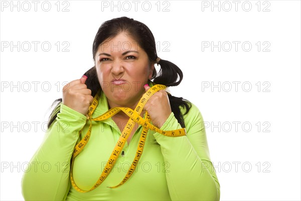 Attractive frustrated hispanic woman tied up with tape measure against a white background