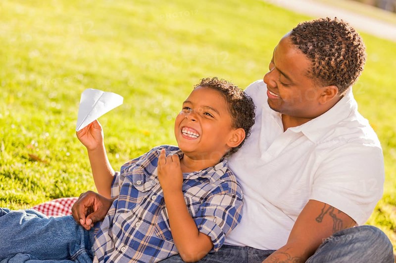 Happy african american father and mixed-race son playing with paper ...