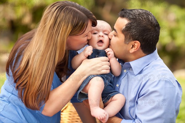 Happy mixed-race parents playing with their giggling son