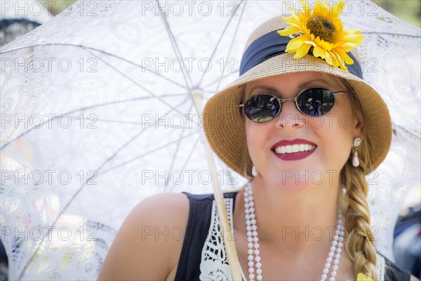 Young attractive woman in twenties outfit holding parasol