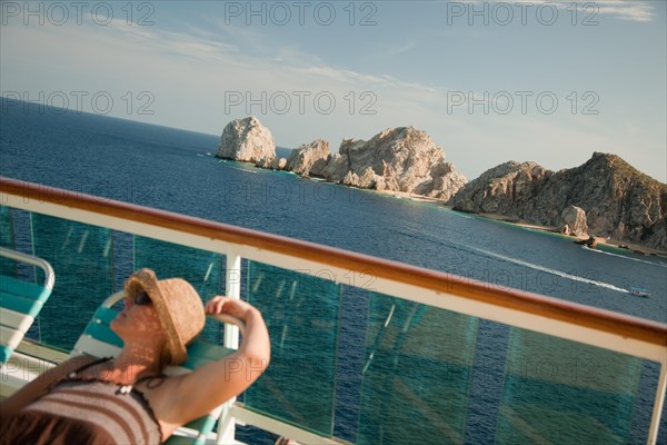 Beautiful woman relaxes on a cruise ship deck at land's end in cabo san lucas