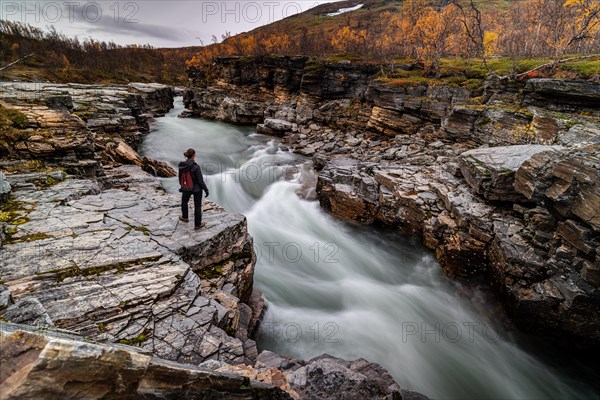 Woman standing at Abiskojakka canyon and river