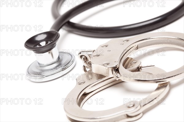 Stethoscope and handcuffs isolated on a white background