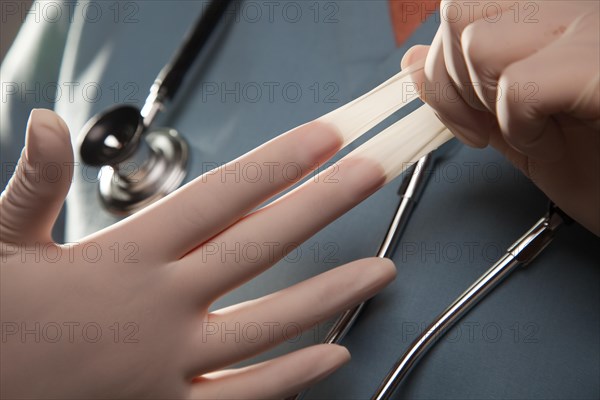 Abstract image of doctor taking off latex surgical gloves
